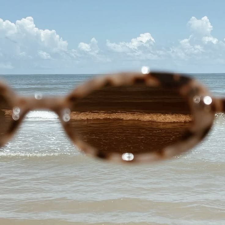 Lentes de sol frente al mar, con el horizonte a través de los cristales.